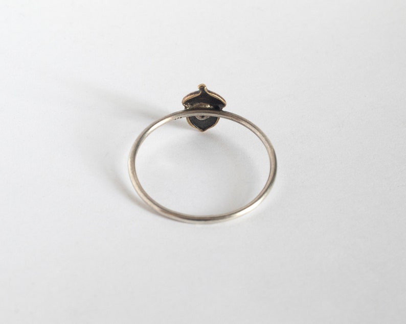 acorn ring with a tiny emerald, from the background on a white background