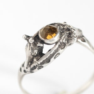 close up of two giraffes ring in silver with rosecut citrine, on a white background