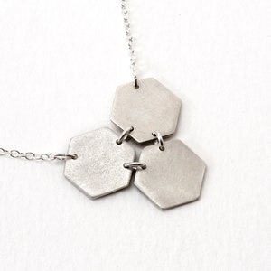 back of three silver hexagons pendant at an angle on white background