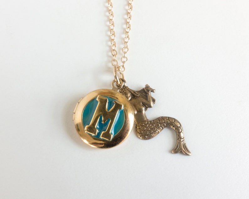 initial locket with mermaid charm, on white background