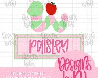 May include: A digital graphic featuring a green and pink striped caterpillar next to a red apple. Below, a rectangular frame contains the name Paisley in pink script. The background is a white grid with pink polka dot borders and text.