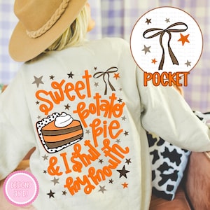 May include: Cream-colored sweatshirt with the words "Sweet Potato Pie & I Shut My Mouth" in orange script. A slice of pie graphic is included. The design also features stars and a pocket graphic.