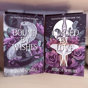 Puede incluir: Dos libros, "Bound by Wishes" y "Cursed by Love" de Jessica Spruill. Las portadas presentan arte de fantasía con una serpiente y una polilla, rodeadas de flores moradas. Pertenecen a la serie "Enchanted Deceptions".