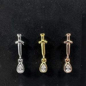 Piercing labret a forma di pugnale con lacrima pendente, filettatura interna, parte posteriore piatta - acciaio chirurgico 316L - disponibile in 16G (1,2 mm) - lunghezza barra 6 mm