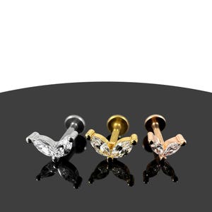 Puede incluir: Tres piezas de joyería corporal de acero quirúrgico con un engaste de gema en forma de marquesa. Las piezas son en plata, oro y oro rosa.