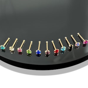 Könnte beinhalten: Ein Set aus zehn goldenen Nasenringen mit bunten Strasssteinen. Die Strasssteine sind in den Farben Rot, Grün, Blau, Pink, Schwarz und Klar.