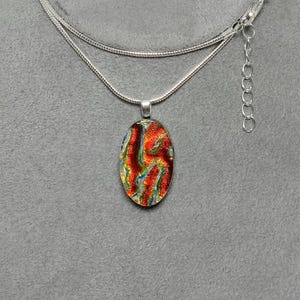 Fused Red Dichroic Glass Small Oval Pendant on Black with a Silver-tone Chain