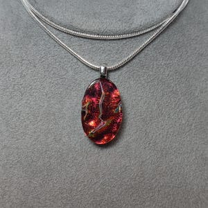 Small Fused Dark Red Dichroic Glass Oval Pendant on Black with a Silver-tone Chain
