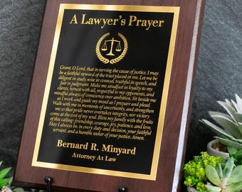 May include: A rectangular wooden plaque with a dark brown finish featuring a black metal plate with gold lettering. The text reads A Lawyer's Prayer, followed by a prayer, the name Bernard R. Minyard, and the title Attorney At Law.