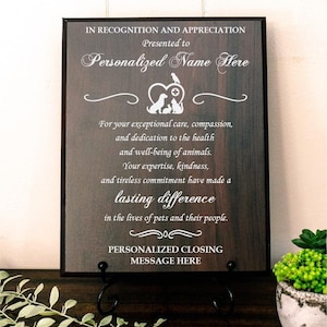 May include: A rectangular dark wood plaque with a black frame featuring white engraved text that reads IN RECOGNITION AND APPRECIATION, Presented to Personalized Name Here, followed by a heart icon with animal silhouettes and a closing message.