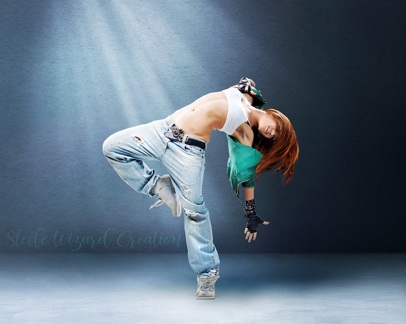 May include: A woman in a white vest top and blue jeans is dancing. She is wearing a green jacket and black gloves. She is posing with her leg extended and her head tilted back.