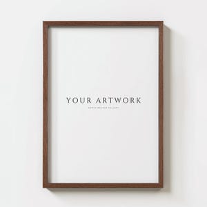 以下が含まれることがあります： 白いマットと黒い文字で「YOUR ARTWORK」と書かれた茶色の木製フレーム。テキストはマットの中央に配置され、その下に「NORTH MOCKUP GALLERY」という文字がより小さなフォントで書かれている。