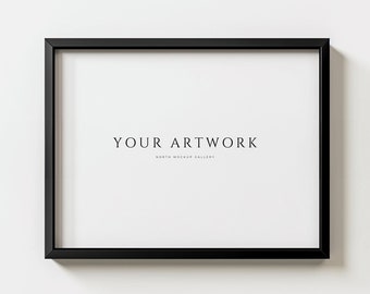 May include: A black picture frame with a white mat and the text "YOUR ARTWORK NORTH MOCKUP GALLERY" on a white wall.