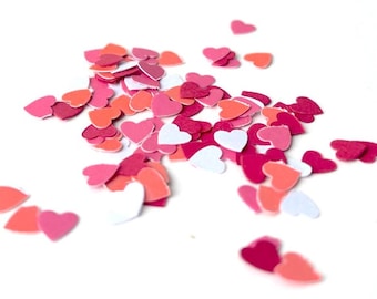 Könnte beinhalten: Eine Streuung von rosa, roten und weißen Papierherzen auf weißem Hintergrund.