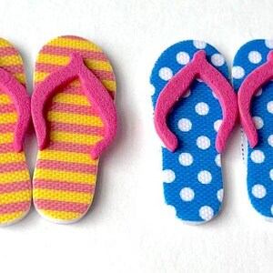 May include: Two pairs of flip-flop sandals. One pair is yellow and pink striped, the other is blue with white polka dots.