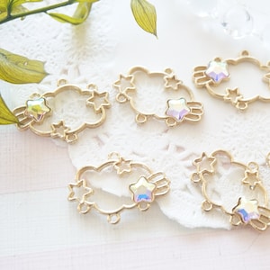May include: Gold-tone metal cloud-shaped charms with iridescent star accents. Each charm has a hole for attaching to jewelry or other crafts.