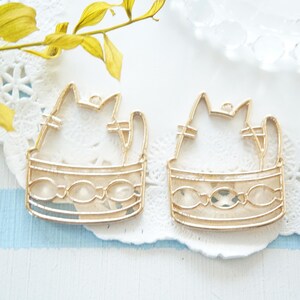 Può includere: Due cornici in metallo dorato a forma di gatto seduto in un vaso. Le cornici sono vuote e pronte per essere riempite con resina.