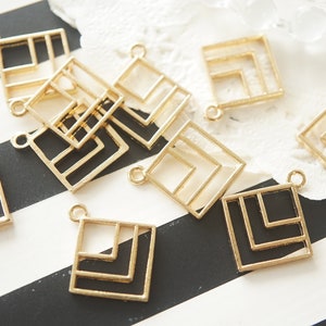 以下が含まれることがあります： 幾何学模様の金色の金属製の正方形のペンダントチャームのグループ。チャームは中が空洞になっており、ジュエリープロジェクトにモダンなタッチを加えるのに最適です。