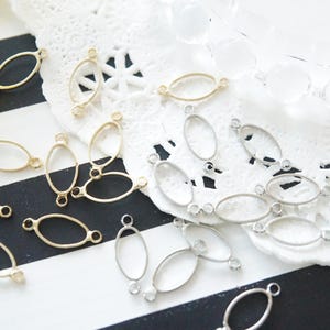 Puede incluir: Surtido de hallazgos metálicos ovalados con anillas de salto. Los hallazgos son en tonos plateados y dorados.