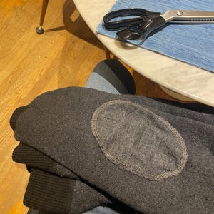 Può includere: Una tazza di ceramica bianca con manico nero e la scritta "But First, Coffee" in nero, con un carattere a mano. La tazza è su una superficie bianca.