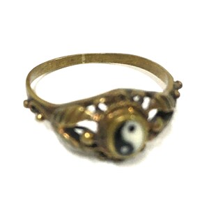 Peut inclure: Une bague en or avec un design complexe repr&eacute;sentant un symbole yin yang noir et blanc.