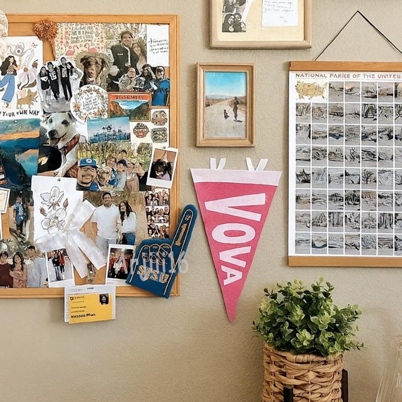 May include: A wall display featuring a corkboard with photos, a pink pennant with "VOVA" in white, a blue foam finger, framed pictures, and a map of the United States. A small potted plant in a woven basket is also visible.