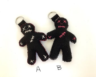 Black felt voodoo doll keychain with pink and white stitching