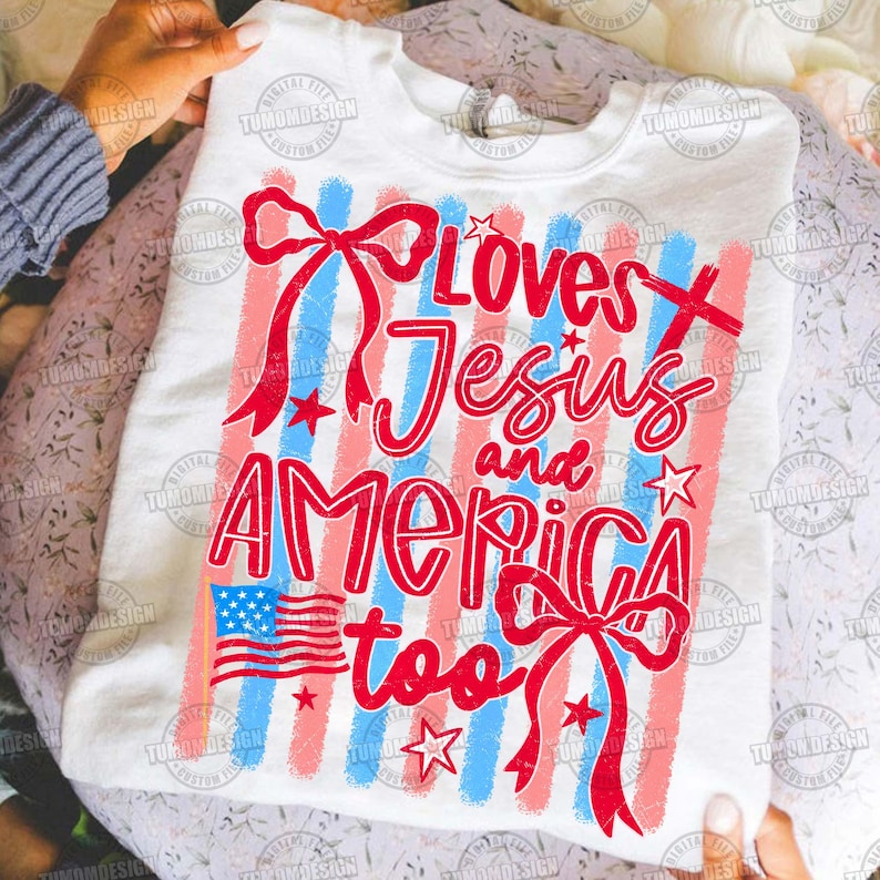May include: White sweatshirt with a patriotic design. The design includes red and blue stripes, a small American flag, stars, and the text "Loves Jesus and America too" in red script.