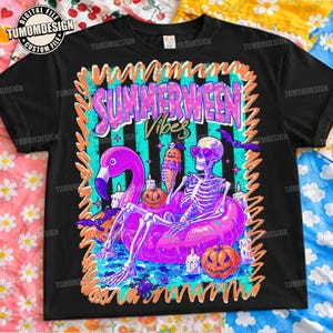 Peut inclure: Un t-shirt noir avec une impression graphique représentant un squelette portant des lunettes de soleil en forme de cœur, assis dans une bouée flamant rose. Le motif inclut des citrouilles, une glace, des chauves-souris et le texte "SUMMERWEEN VIBES".
