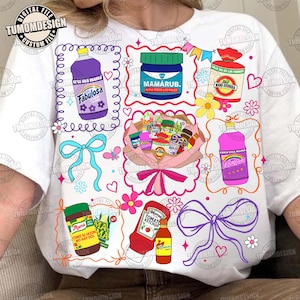 Könnte beinhalten: Ein Set aus drei Keramikbechern mit gesprenkelter, matter Oberfläche. Die Becher sind in den Farbtönen Creme, Hellgrau und Dunkelgrau gehalten. Jeder Becher hat ein schlichtes, minimalistisches Design und einen abgerundeten Henkel.