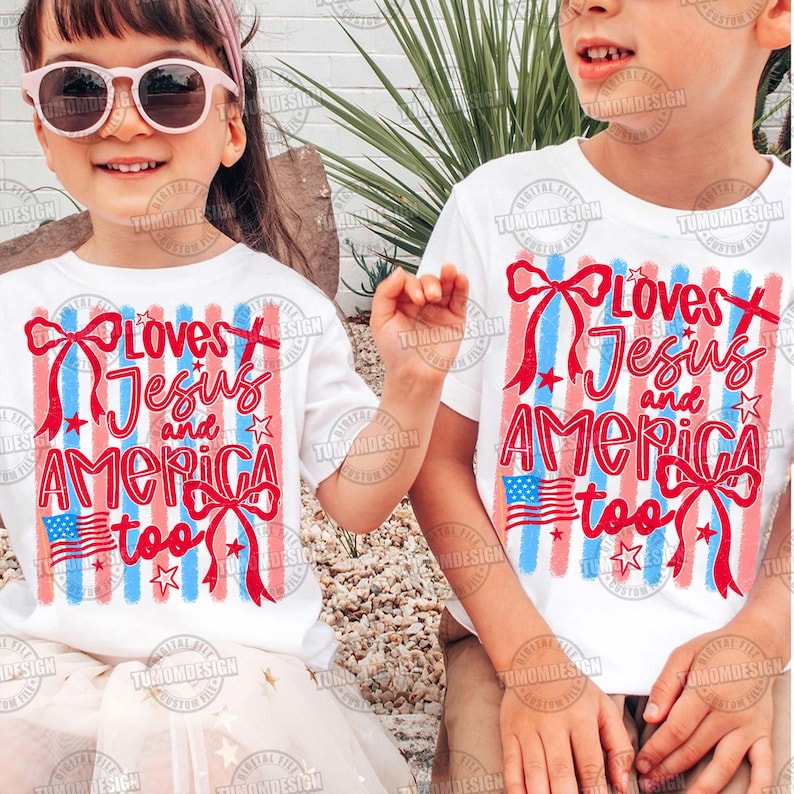 May include: Two children wearing white t-shirts with the text "Loves Jesus and America too" in red and blue. The design includes red bows, blue and red stripes, stars, and an American flag. The children are smiling.