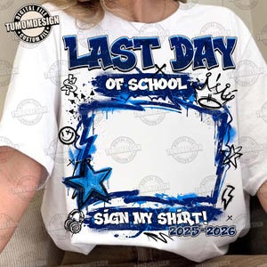 以下が含まれることがあります： 青と白のグラフィックデザインの白いTシャツ。「LAST DAY OF SCHOOL」と「SIGN MY SHIRT！2025-2026」の文字が入っています。グラフィックには、星、王冠、その他の装飾要素も含まれています。