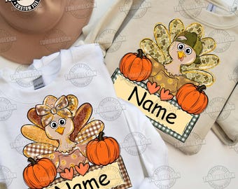 May include: Two sweatshirts with turkey and pumpkin graphics. One is white, the other is beige. Each has a turkey design with a bow or cap, pumpkins, and a banner that says "Name". The designs are in shades of brown, orange, and green.