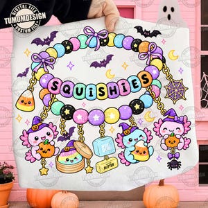 Może przedstawiać: Biały nadruk graficzny przedstawiający wzór naszyjnika z koralików z napisem SQUISHIES. Ilustracja zawiera pastelowe koraliki, fioletowe kokardki, nietoperze, księżyce, pajęczynę oraz trzy aksolotle w czarodziejskich kapeluszach z dyniami.