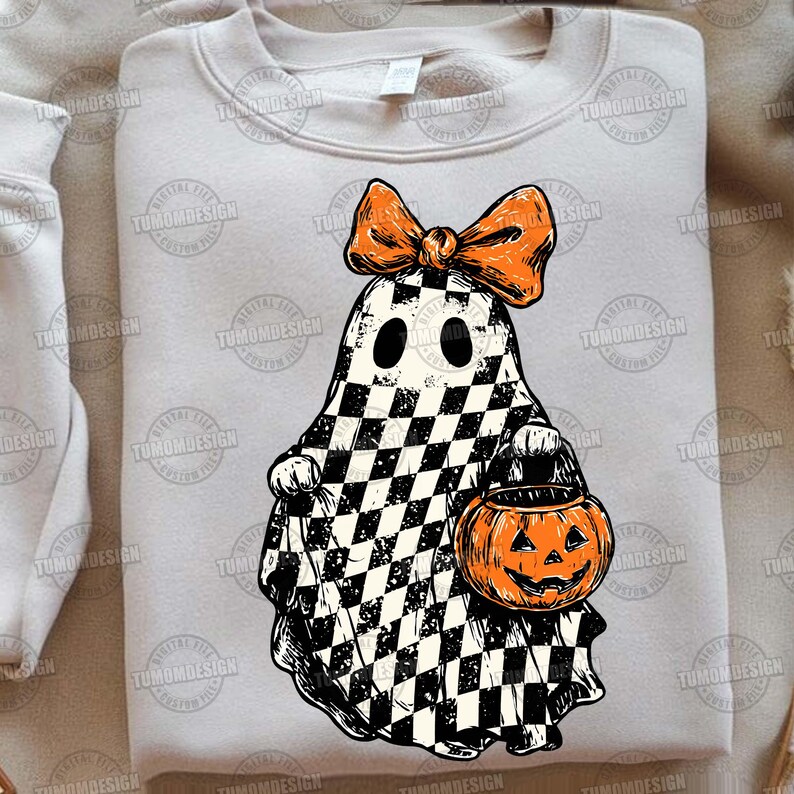 K&ouml;nnte beinhalten: Ein hellgraues Sweatshirt mit einem Halloween-Geist-Design. Der Geist ist schwarz-wei&szlig; kariert, mit einer orangefarbenen Schleife und einem K&uuml;rbis. Eine lustige und festliche Wahl f&uuml;r die gruselige Jahreszeit.