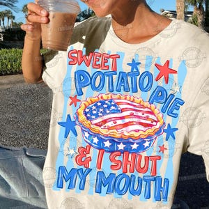 May include: Cream-colored t-shirt with a graphic of a sweet potato pie decorated with the American flag. The text on the shirt reads "Sweet Potato Pie & I Shut My Mouth" in red and blue.