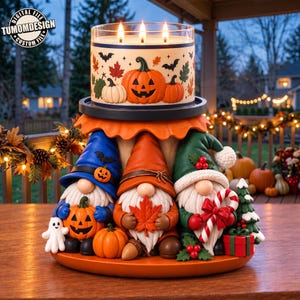 Puede incluir: Una vela de tres mechas sobre un soporte decorativo con tres gnomos. El gnomo azul sostiene una calabaza, el naranja una hoja de arce y el verde un bastón de caramelo. Una pequeña figura de fantasma acompaña al conjunto.