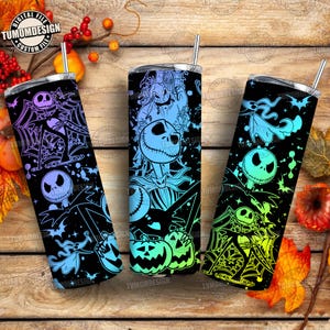 Könnte beinhalten: Drei schwarze, isolierte Becher mit Halloween-Motiven. Jeder Becher hat ein anderes Design mit Jack Skellington, Spinnweben und Fledermäusen in Blau-, Lila- und Grüntönen. Die Becher haben silberne Deckel und Strohhalme.