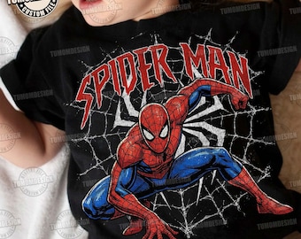 May include: A black t-shirt featuring a graphic of the character Spider-Man in a crouching pose against a white spiderweb background. The text SPIDER MAN is printed in large, distressed red letters above the character. The design has a vintage look.
