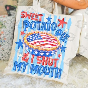 May include: A cream-colored tote bag with a patriotic design. The bag features the text "SWEET POTATO PIE & I SHUT MY MOUTH" in red and blue, along with a pie decorated with the American flag and stars.