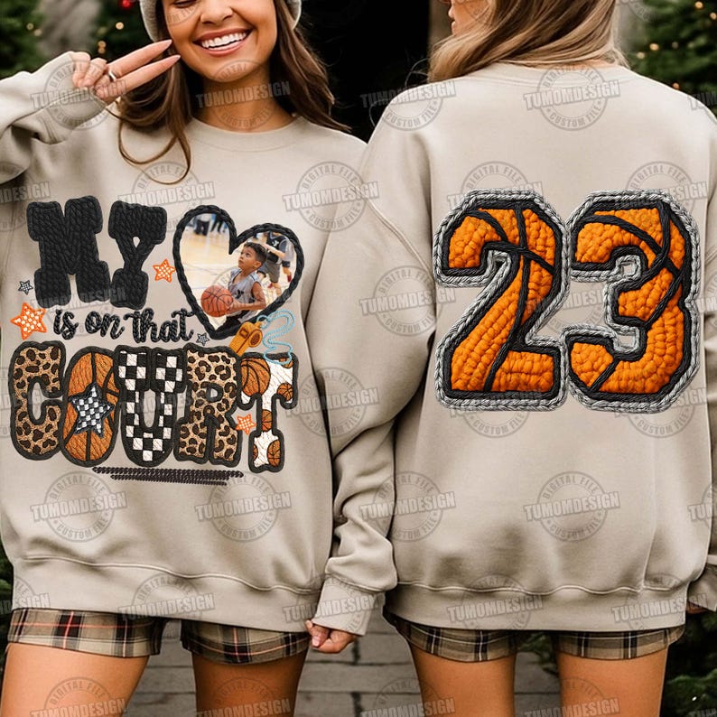 May include: Beige sweatshirt with a basketball design. The front has the text "My is on that COURT" with a heart-shaped photo and basketball graphics. The back shows the number "23" in an orange basketball design.