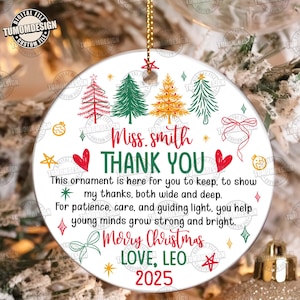 May include: A white Christmas ornament with a gold string, featuring a festive design. It includes Christmas trees, hearts, and the text "Miss Smith THANK YOU Merry Christmas LOVE, LEO 2025".