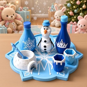May include: A light blue snowflake-shaped serving tray holding a white snowman figurine, two blue bottles with snowflake and crown graphics, two blue hexagonal cups, and a white igloo-shaped bowl with a matching blue spoon on a wooden surface.