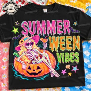 Peut inclure: Un t-shirt noir avec un motif de squelette aux cheveux blonds portant un chapeau de soleil rose et des lunettes en forme de cœur, allongé dans une bouée citrouille en tenant un cocktail. Le texte indique SUMMER WEEN VIBES en police dégoulinante.