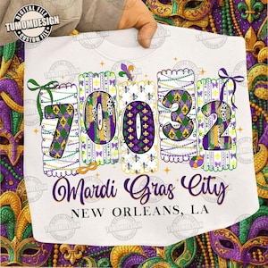 Könnte beinhalten: Weißes Sweatshirt mit Mardi Gras-Motiv. Das Design zeigt die Zahlen "70032" in Lila, Grün und Gold, mit den Worten "Mardi Gras City, New Orleans, LA" in lila Schrift.