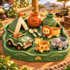 Könnte beinhalten: Ein grünes Tablett mit einem Miniaturzelt, einem Safari-Jeep, einem Löffel, einer Gabel und tierförmigen Behältern als Löwe, Giraffe und Elefant sowie zwei strukturierten Töpfen mit Safarimotiven und dem Text TUMOMDESIGN.
