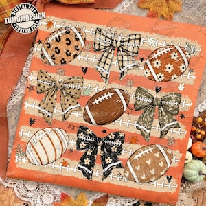 May include: An orange digital print featuring footballs and bows. The footballs have leopard, floral, and heart patterns. The bows feature plaid, polka dot, and leaf designs. The background includes white football laces and small leaves.