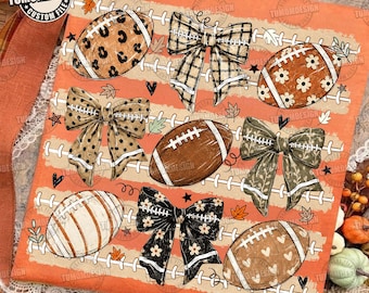 May include: An orange digital print featuring footballs and bows. The footballs have leopard, floral, and heart patterns. The bows feature plaid, polka dot, and leaf designs. The background includes white football laces and small leaves.