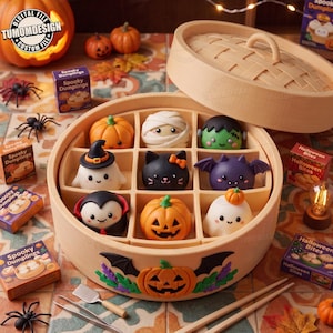 May include: A round bamboo steamer containing nine small, colorful Halloween-themed figurines shaped like dumplings, including pumpkins, a mummy, a ghost, a black cat, a bat, and a vampire. The steamer features a carved pumpkin and bat decoration.