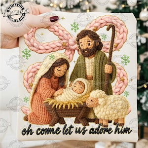 Può includere: Scena natalizia all'uncinetto raffigurante Maria, Giuseppe e Gesù bambino in una mangiatoia, con una pecora. L'immagine ha un'aureola intrecciata rosa e la scritta "oh come let us adore him". Le figure sono in tonalità marrone, beige e verde.
